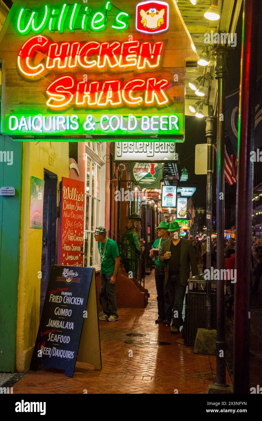 Quartiere Francese, New Orleans, in Louisiana. Bourbon Street marciapiede di notte. Uomini vestiti in verde per festeggiare il giorno di San Patrizio. Foto Stock