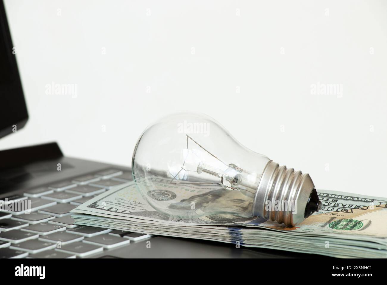 La lampada a incandescenza si basa sui dollari del computer portatile, sul prezzo elevato dell'elettricità, acquista luce online Foto Stock