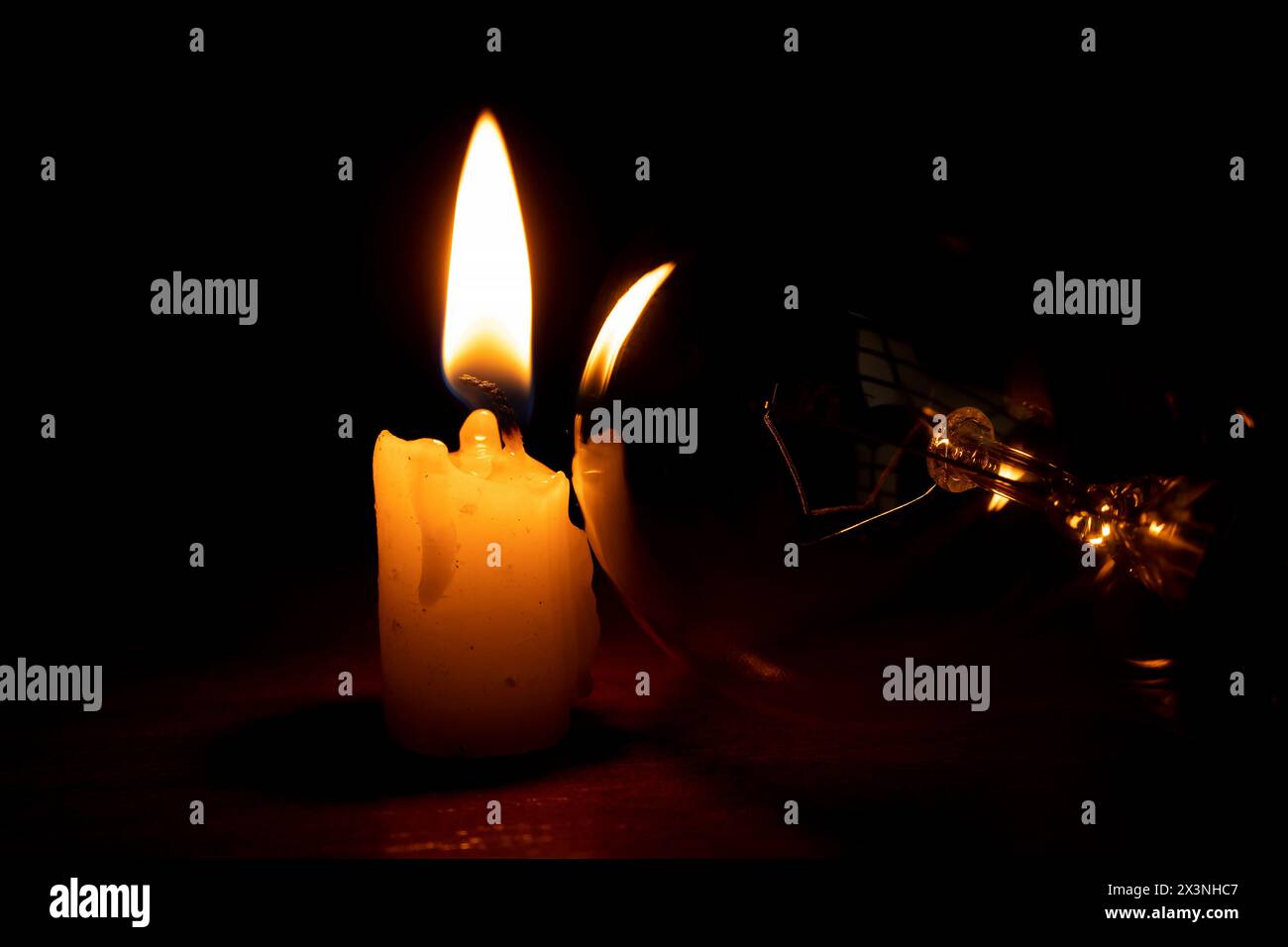 Lampada a incandescenza e candela al buio a casa, senza luce Foto Stock