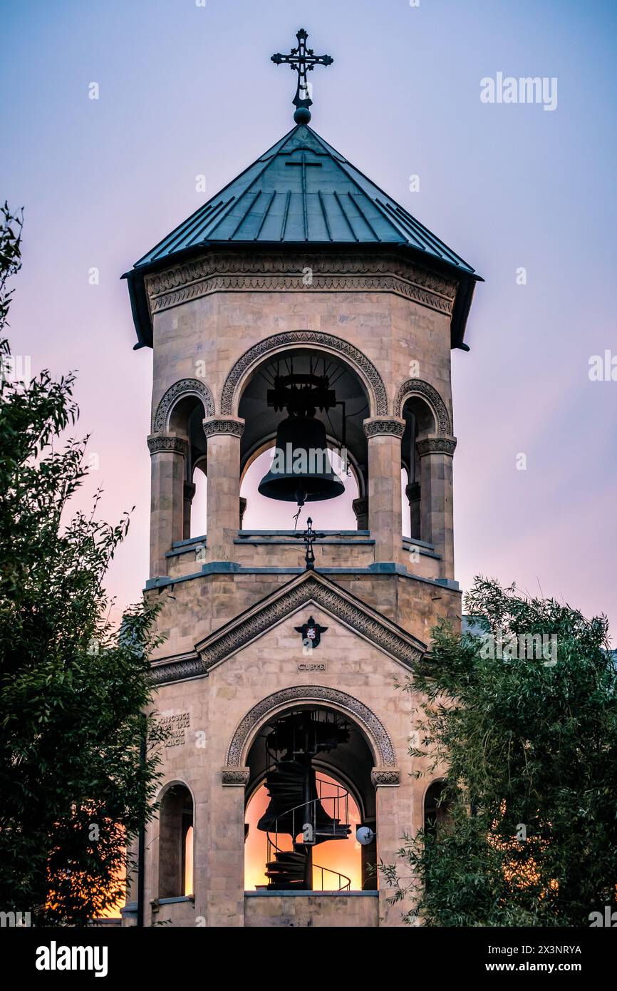 Campanile vicino alla cattedrale di Sameba al tramonto a Tbilisi, Georgia Foto Stock