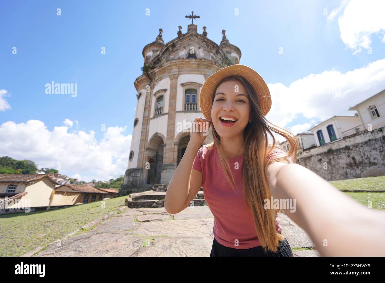 Selfie a Ouro Preto, Brasile. Giovane donna turistica che si fa autoritratto con la chiesa di nostra Signora del Rosario a Ouro Preto destinazione turistica Foto Stock