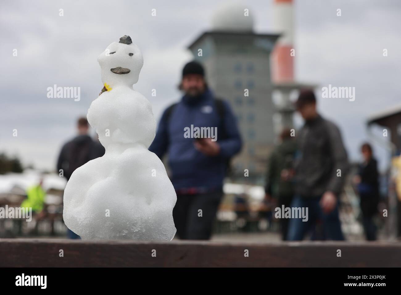 Schierke, Germania. 28 aprile 2024. Un pupazzo di neve sta su un tavolo sul Brocken. Nonostante le temperature miti, c'è ancora un po' di neve sul Brocken. Le temperature rimarranno miti nei prossimi giorni. Crediti: Matthias Bein/dpa/Alamy Live News Foto Stock