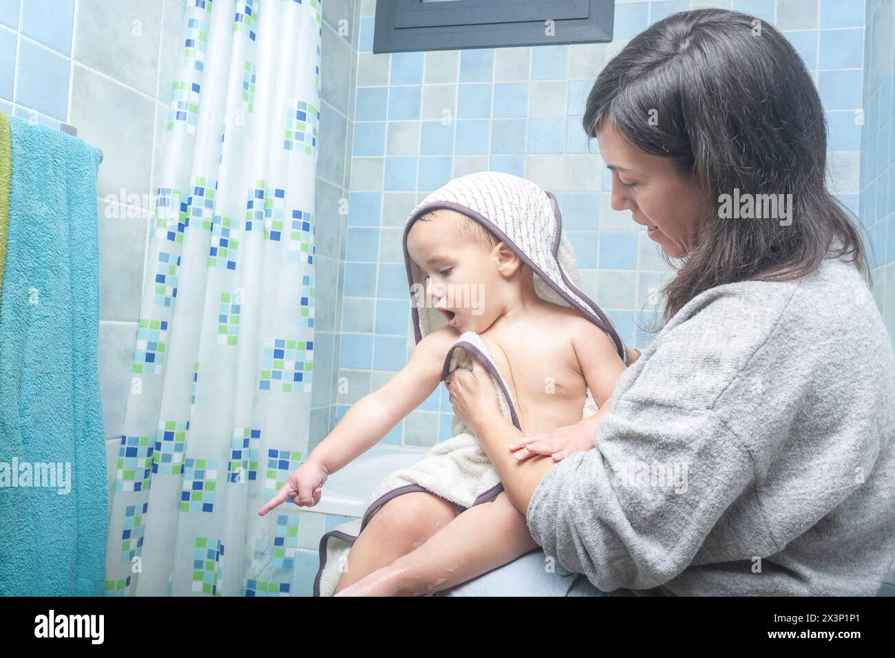 Madre che dà il benvenuto a suo figlio dopo una doccia Foto Stock