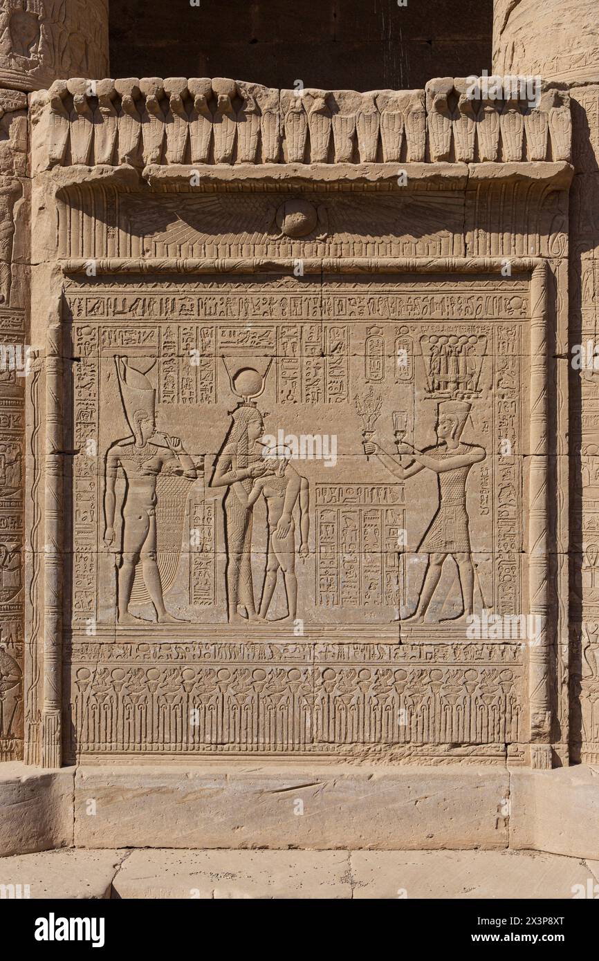 Sollievo dell'imperatore romano Traiano che offre fiori e un sistro a Hathor che succhia suo figlio e Ihy nella casa natale del complesso del Tempio di Dendera Foto Stock