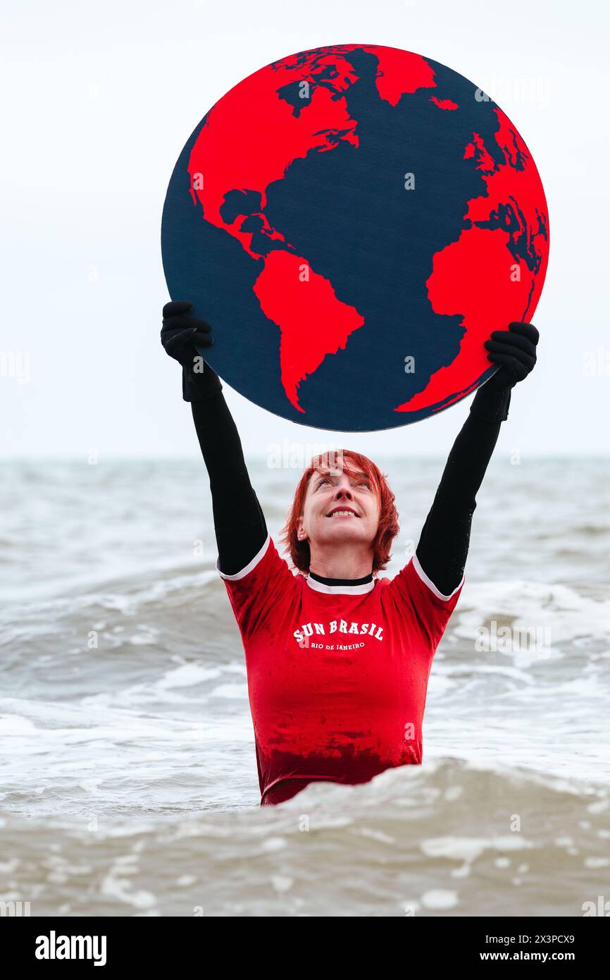 Una donna tiene un globo sul mare mentre il Festival della Scienza di Edimburgo celebra la Giornata della Terra, Edimburgo, Scozia, Regno Unito Foto Stock
