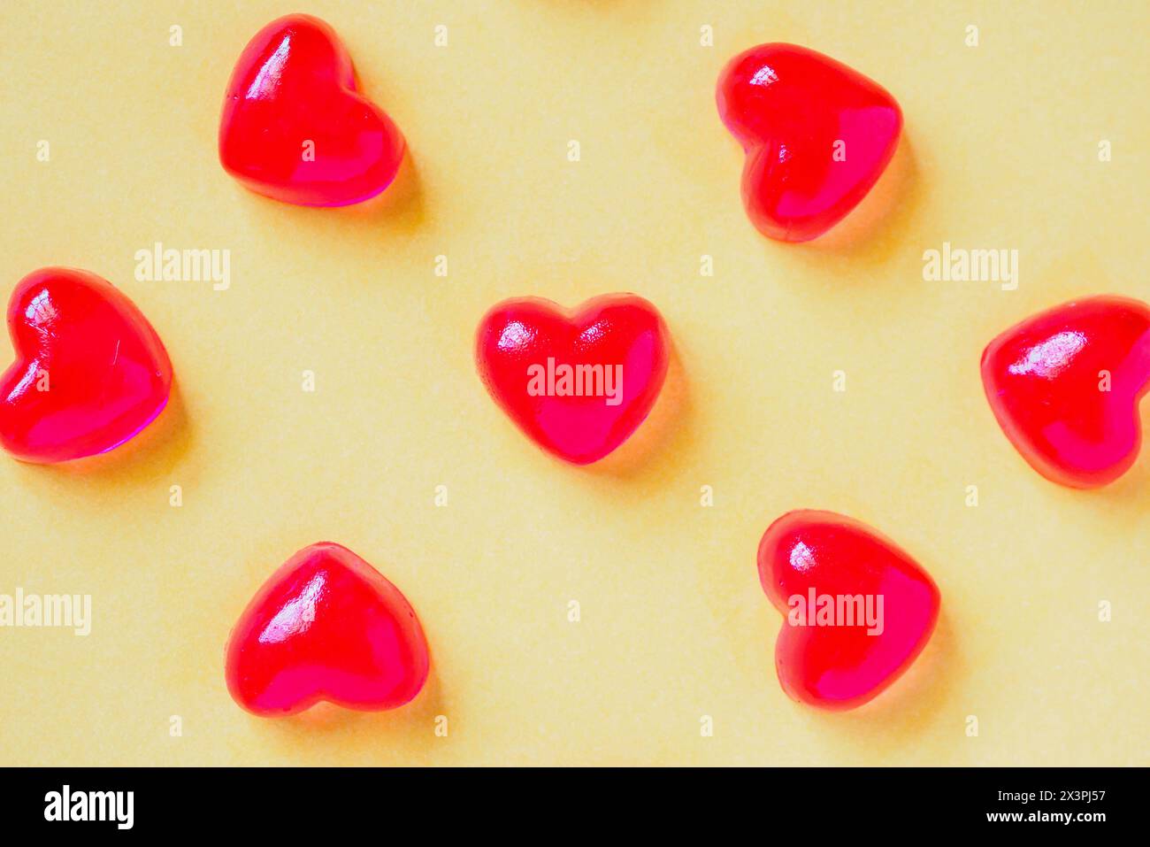 San Valentino sfondo con cuore rosso caramella forma su sfondo giallo Foto Stock