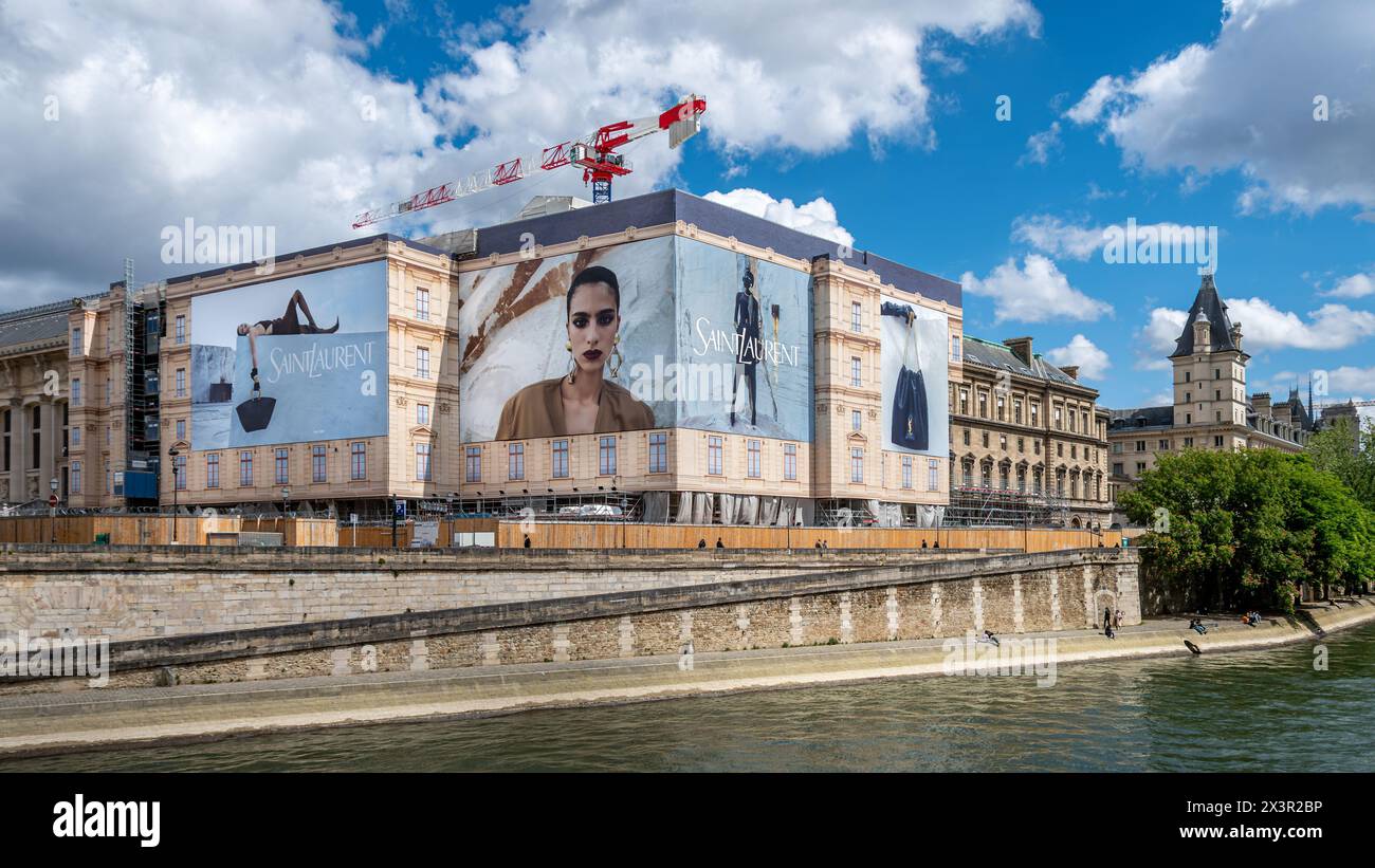 Grandi cartelloni pubblicitari di Yves Saint Laurent che coprono le impalcature dei lavori di restauro di un edificio lungo la Senna, Parigi, Francia Foto Stock