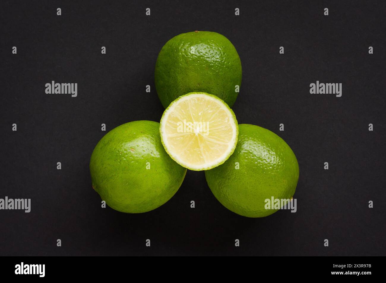 Limes verdi con una mezza lime a fette Foto Stock