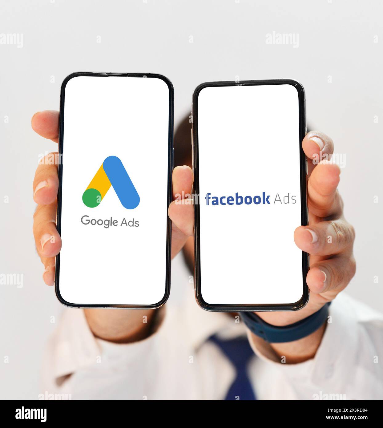 Confronto tra annunci Google Ads e annunci Facebbook in termini di performance, persona che mostra su schermo mobile editoriale. Foto Stock