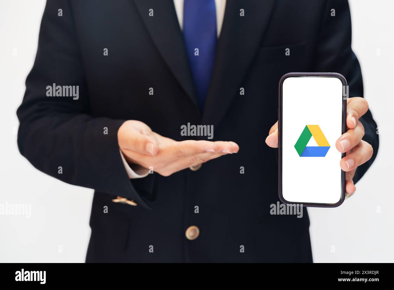Uomo che usa Google Dribe su Mobile e che punta verso di esso con l'altra parte, background editoriale. Cloud Storage che fornisce all'azienda lo sfondo di google Drive Foto Stock