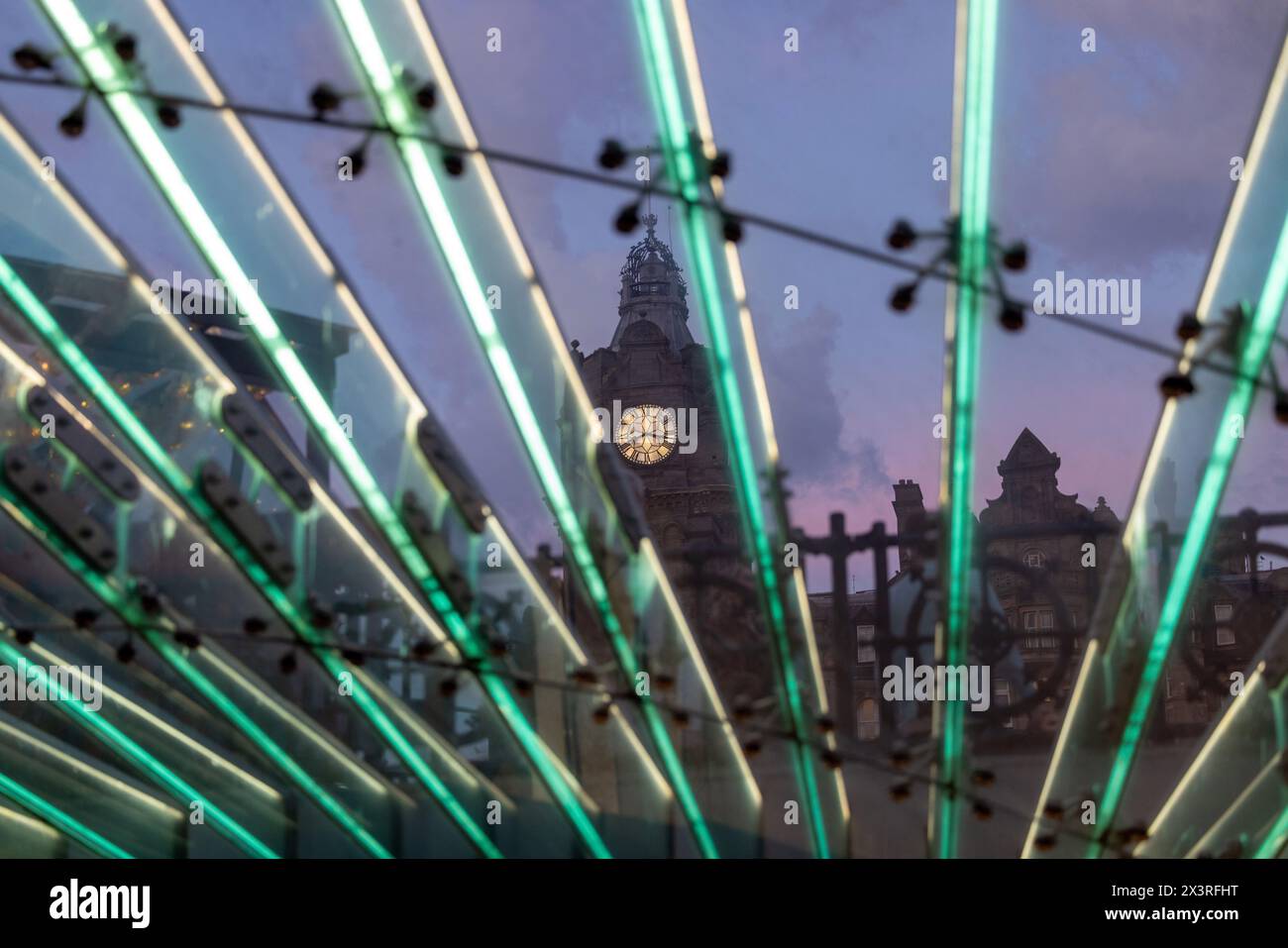 La torre dell'orologio del Balmoral Hotel di Edimburgo, vista al crepuscolo attraverso l'ingresso della stazione di Waverley Foto Stock