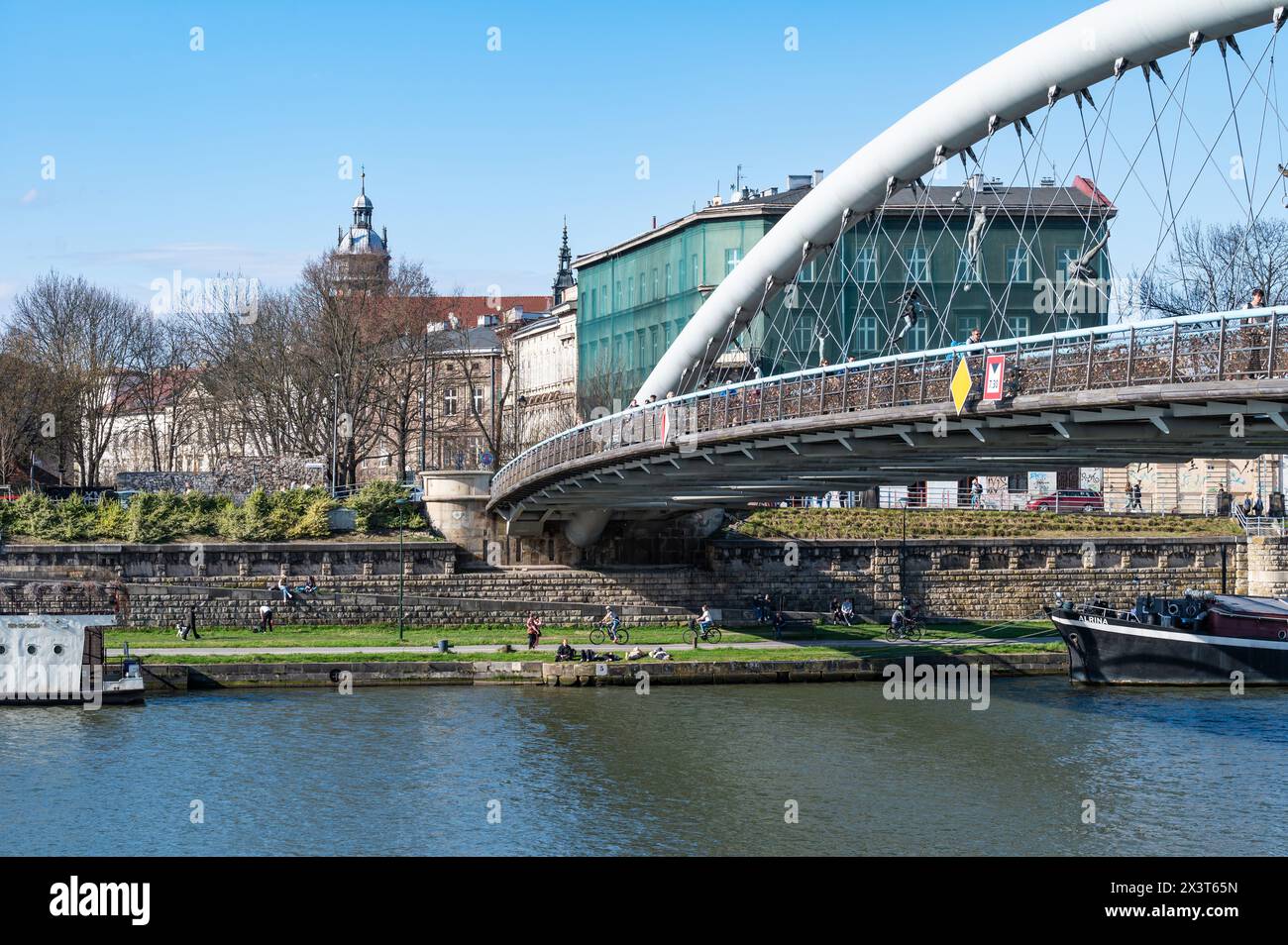 Cracovia, Polonia, 23 marzo 2024 - il padre Bernatek a piedi - e ponte per biciclette sul fiume Wisla Foto Stock