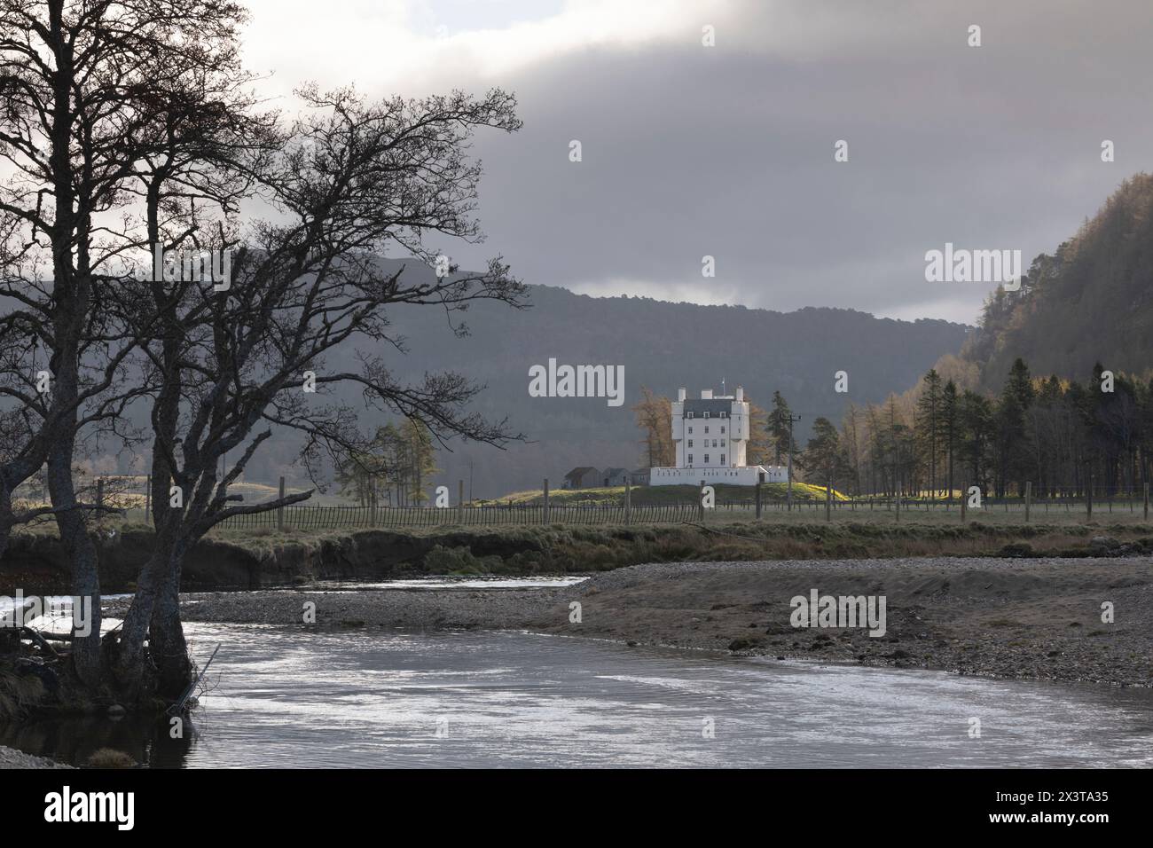 Una vista sull'acqua di Clunie nel Parco Nazionale di Cairngorms verso il Castello di Braemar, sorpreso dalla luce del sole in una mattinata sopraffatta Foto Stock