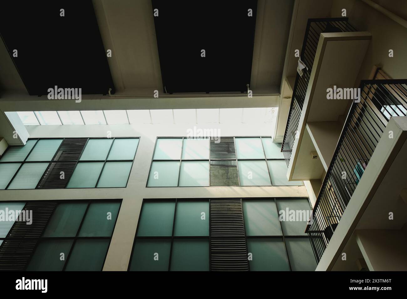 Alto edificio con facciata in vetro che presenta finestre scure e struttura in metallo Foto Stock