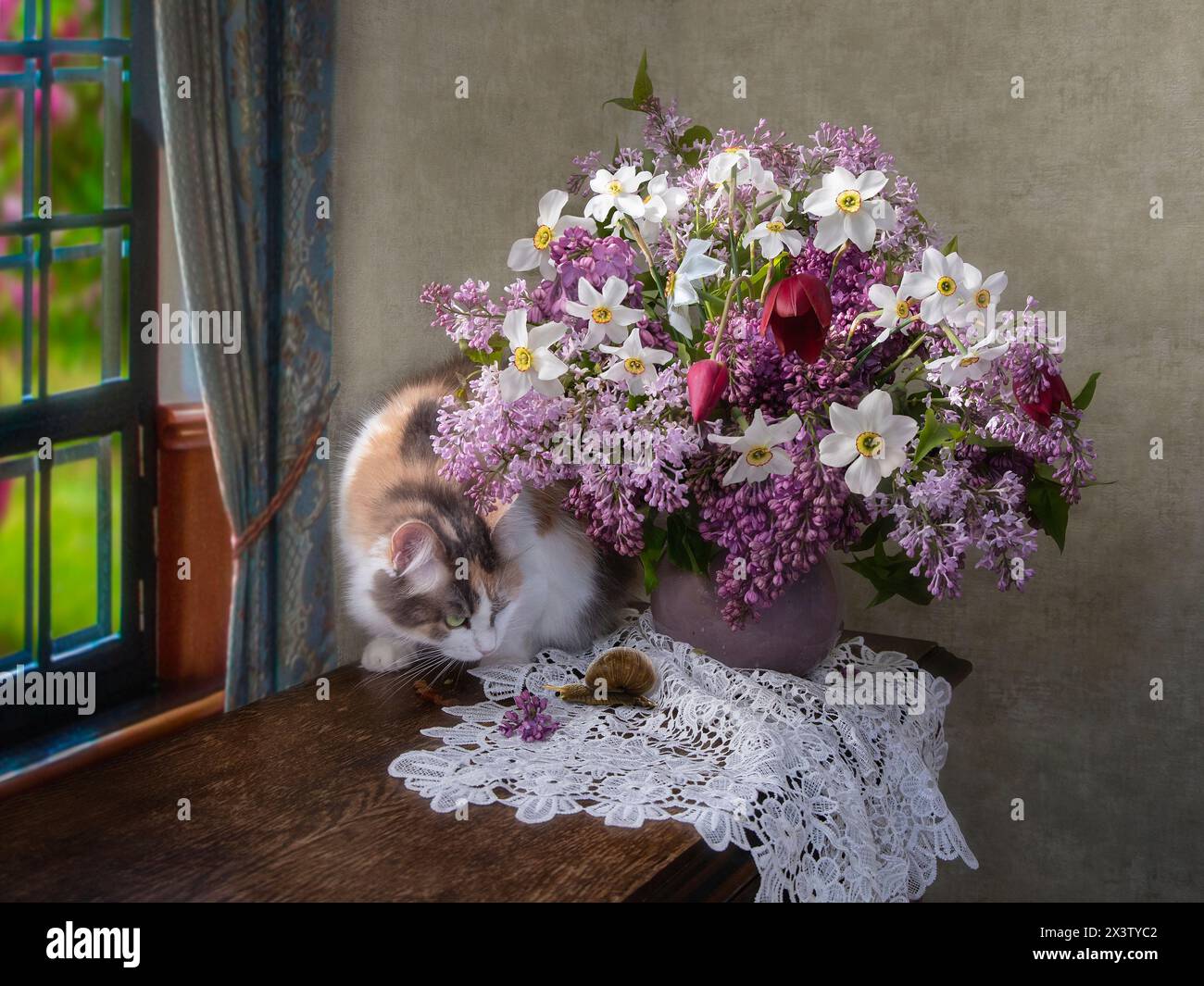 Curioso gattino e bouquet di lilla e fiori Foto Stock