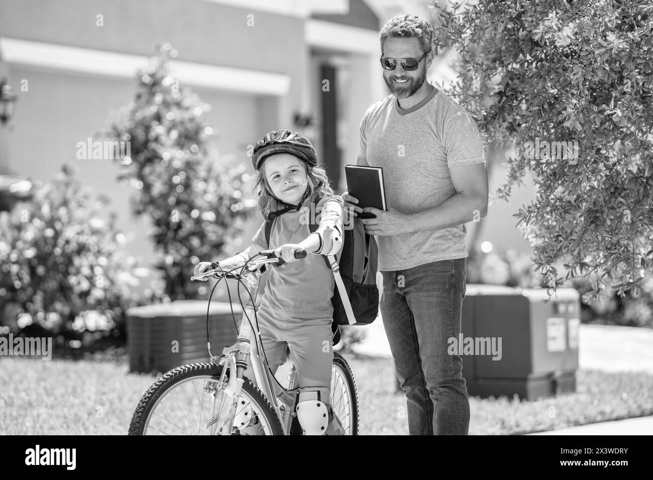 padre che insegna a suo figlio a andare in bicicletta. padre e figlio all'aperto. padre e figlio si divertono a fare un giro in bicicletta insieme. un duo attivo di figli e padre Foto Stock
