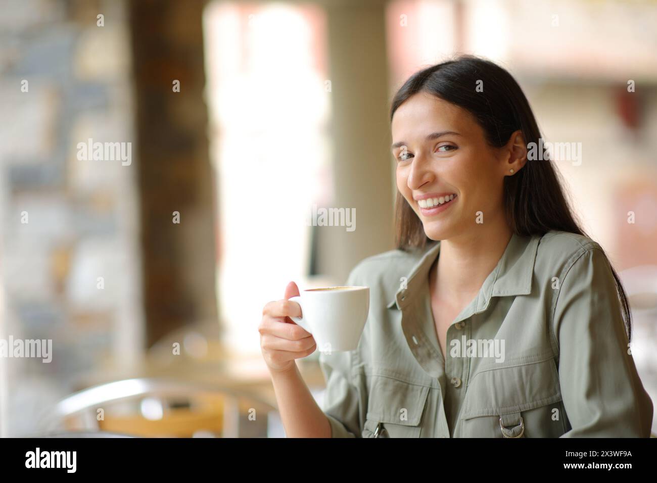 I clienti del ristorante che hanno in mano una tazza di caffè che ti guardano sulla terrazza del ristorante Foto Stock