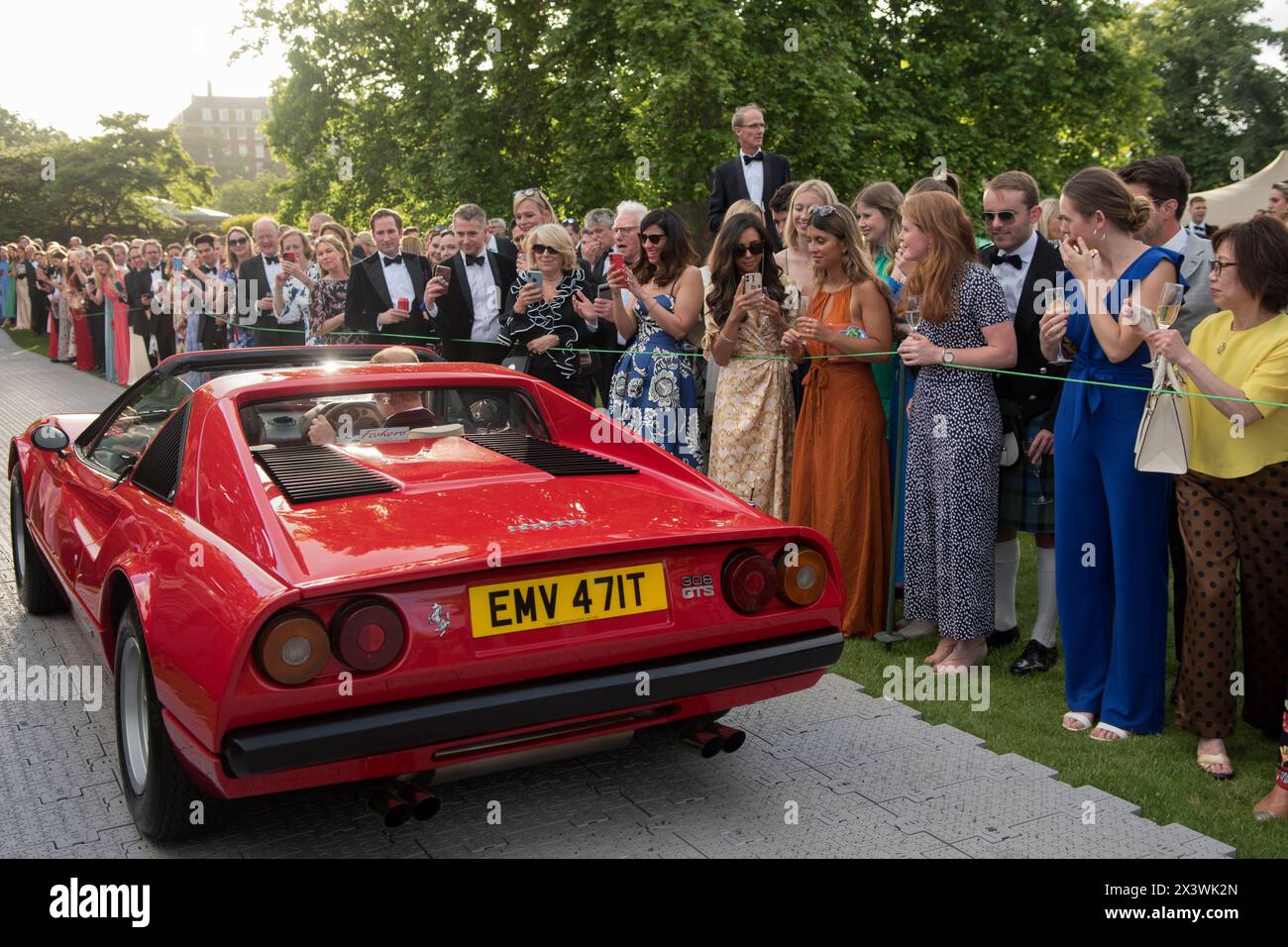 Benestante festa estiva annuale in giardino dell'Hurlingham Club a Londra, membri che guardano una Ferrari 308 GTS rossa nel Concourse d'Elégance. I membri mettono in mostra le loro auto d'epoca e d'epoca nel Concourse d'Elégance, cioè i proprietari guidano le auto nei terreni del club. Fulham, Londra, Inghilterra 11 giugno 2022 UK 2020s HOMER SYKES Foto Stock