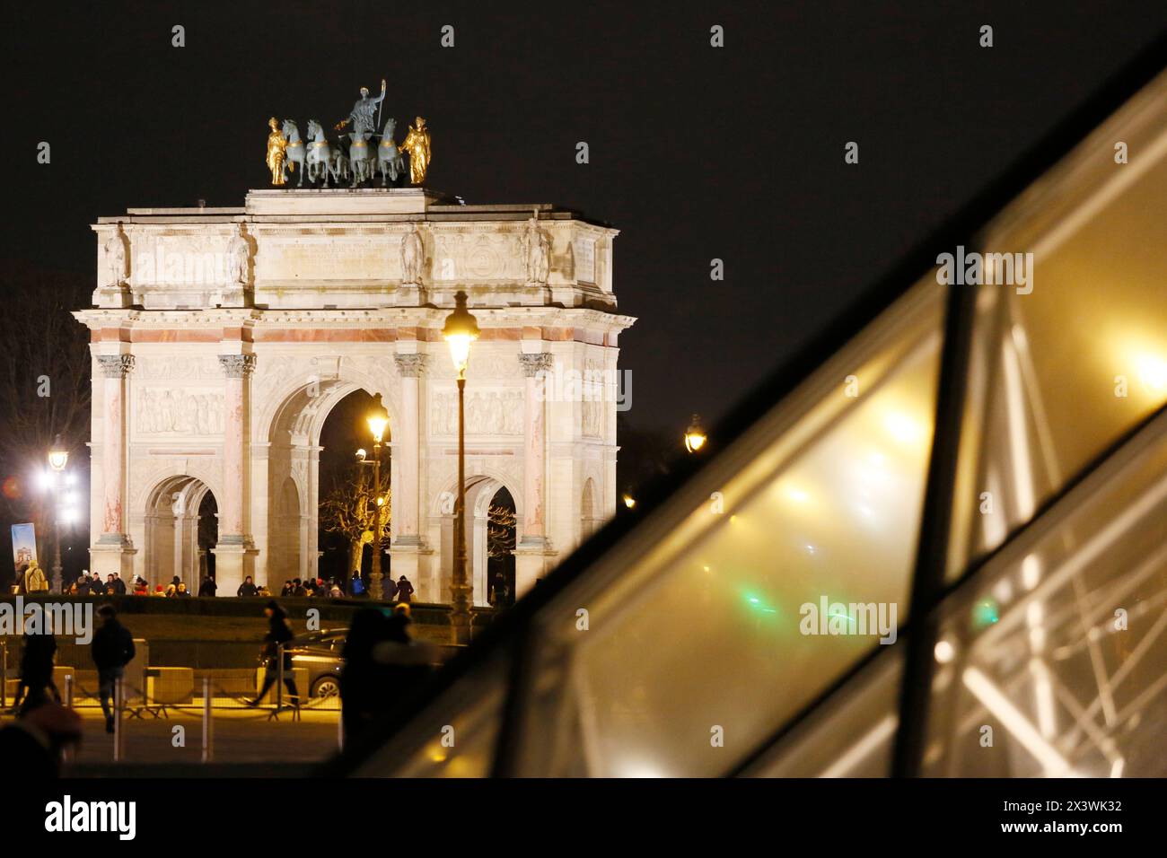 Parigi. 1° distretto. Museo del Louvre di notte. In primo piano si trova la piramide (architetto: Ieoh Ming Pei). Sullo sfondo, l'arco trionfale del Foto Stock