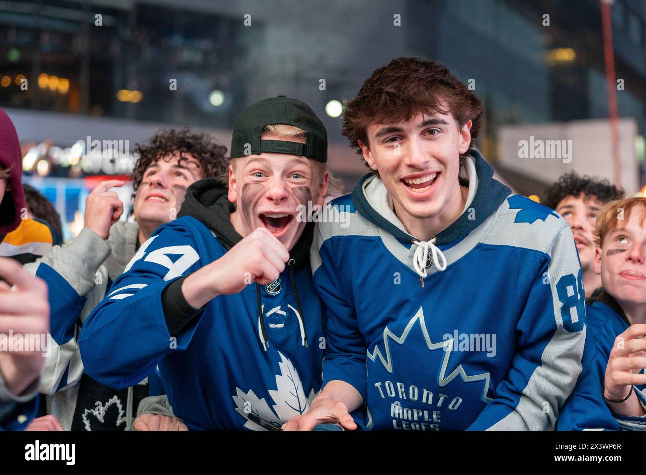 I tifosi che guardano la partita su uno schermo gigante reagiscono mentre i Toronto Maple Leafs segnano un gol contro i Boston Bruins durante il primo turno, gara 4 a Maple Leaf Square fuori dalla Scotiabank Arena. Durante le partite di playoff dei Toronto Maple Leafs, Maple Leaf Square si trasforma in un mare di blu e bianco, riecheggiando i canti dei tifosi appassionati che si radunano con entusiasmo dietro la ricerca della vittoria della loro squadra. L'atmosfera elettrica irradia attesa ed eccitazione, creando ricordi indimenticabili sia per i sostenitori che per gli osservatori occasionali. Foto Stock