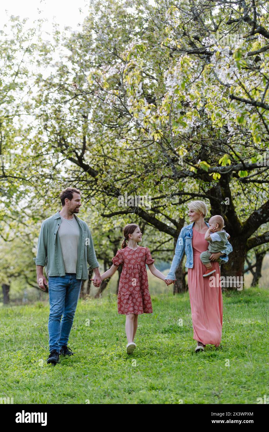 Ritratto di famiglia con la figlia e il bambino piccolo, il bambino, camminando all'aperto nella natura primaverile. Foto Stock