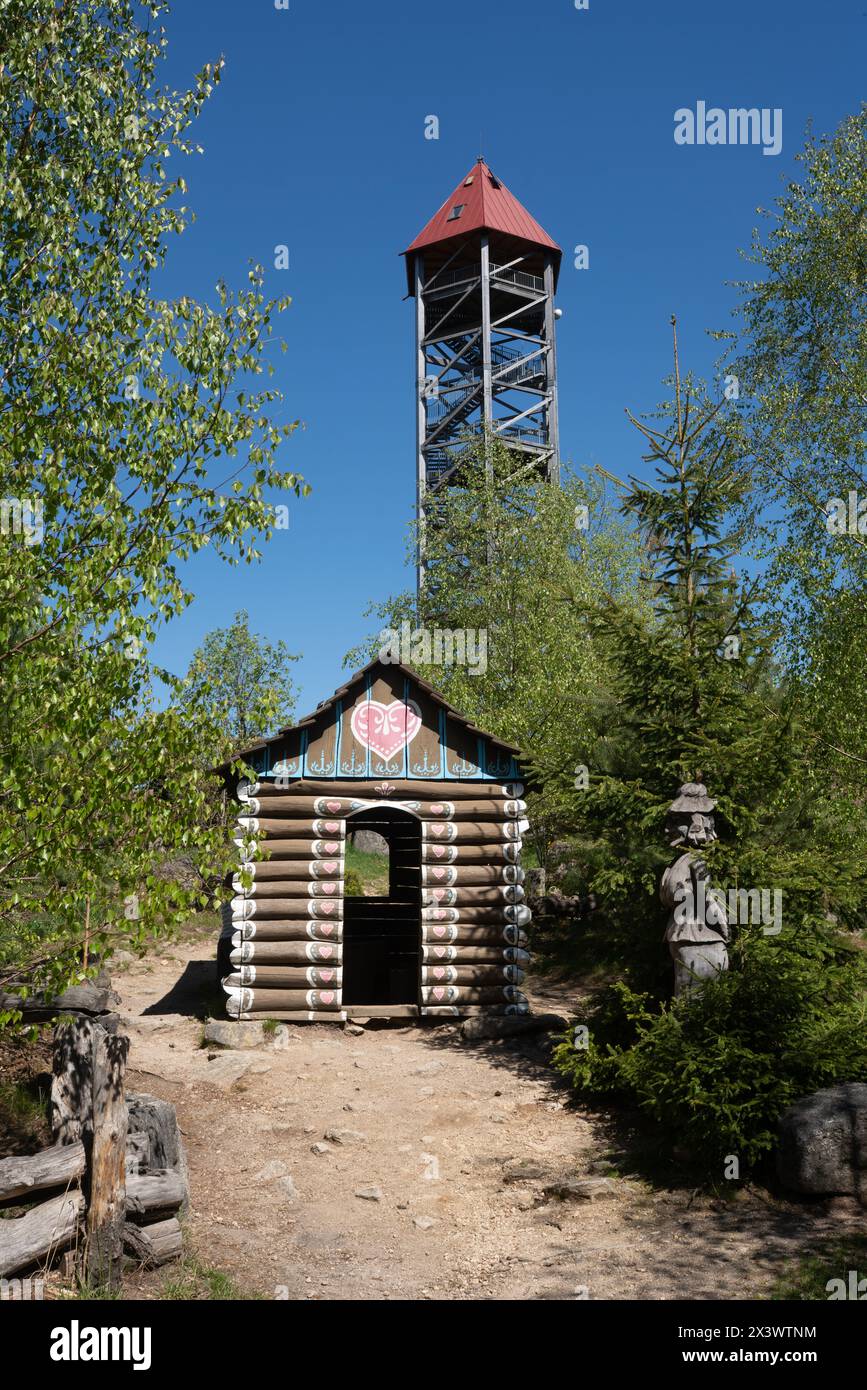 Torre di osservazione "U Jakuba" vicino a Kunžak, Moravia sud-occidentale. Casa di pan di zenzero in legno con una statua di una strega davanti come parte del parco giochi. Foto Stock