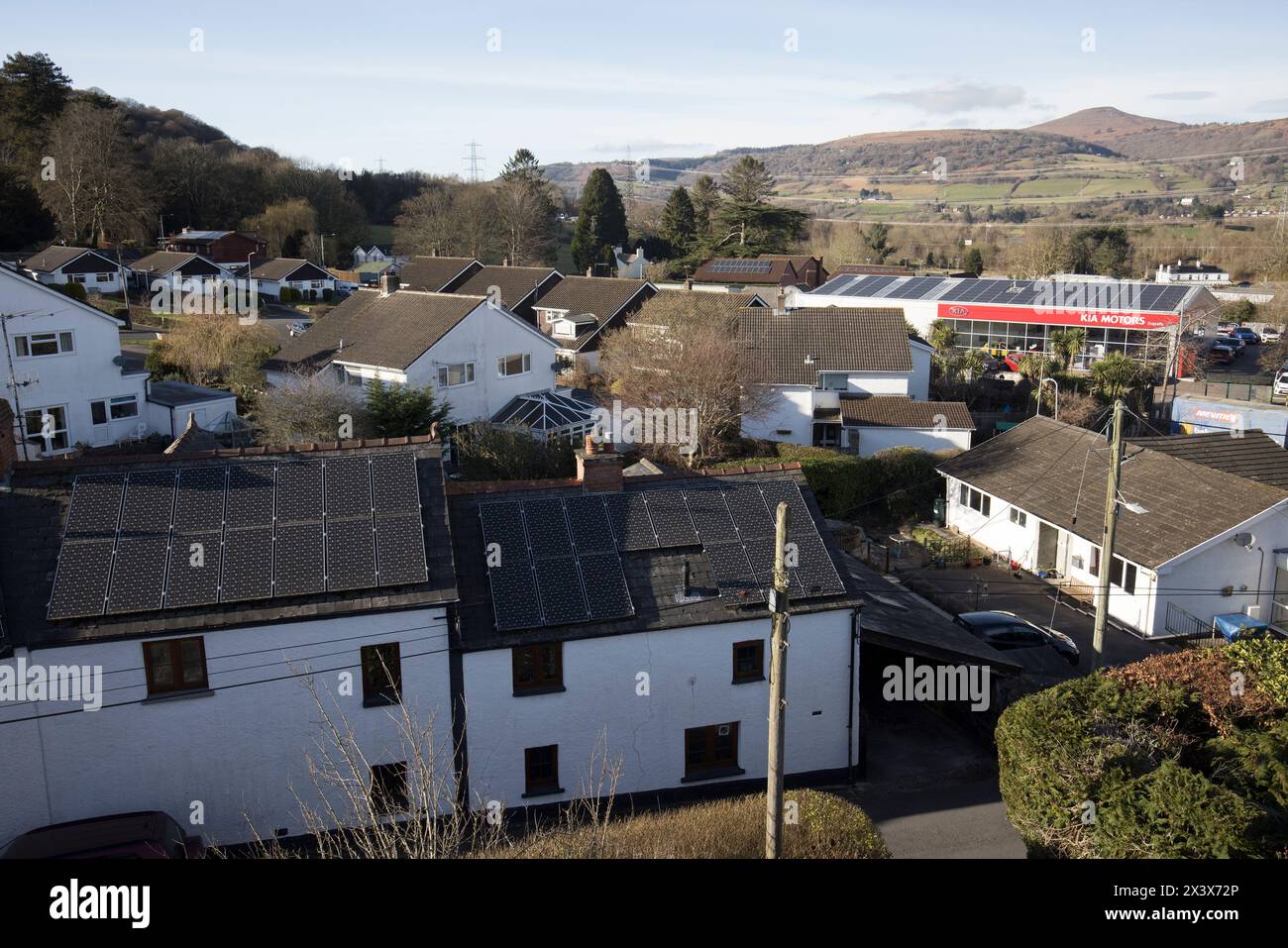 Pannelli solari sui tetti di case e aziende, con uno influenzato da ombra, Llanfoist, Galles, Regno Unito Foto Stock