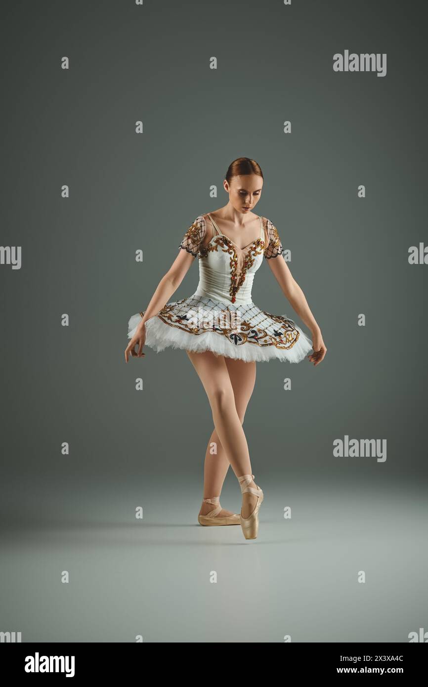 Una giovane e bella ballerina si mette in posa con grazia in un tutù bianco. Foto Stock