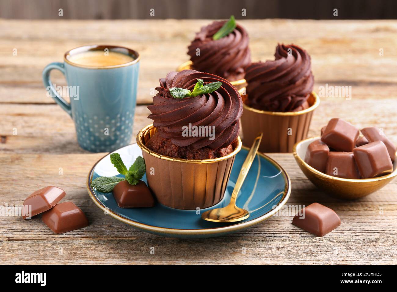 Deliziosi cupcake con pezzi di menta e cioccolato su un tavolo di legno Foto Stock