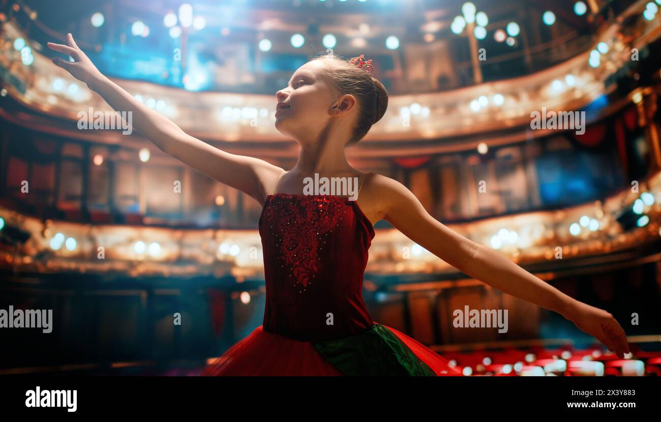 Una bambina carina che sogna di diventare una ballerina. Bambina in un tutu rosso che danza sul palco. Foto Stock