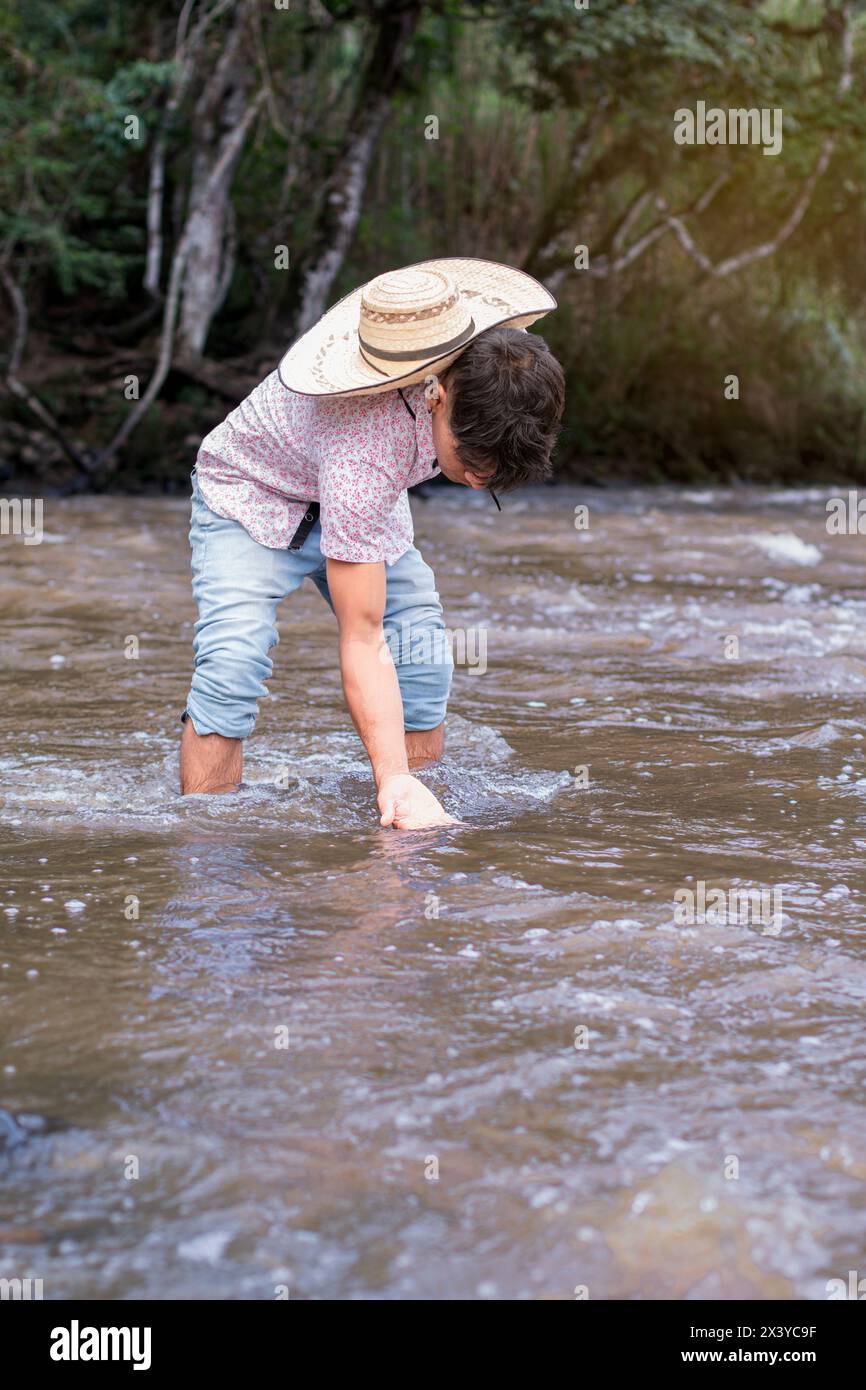 stile di vita. l'uomo nativo immerge la mano nell'acqua del fiume Foto Stock