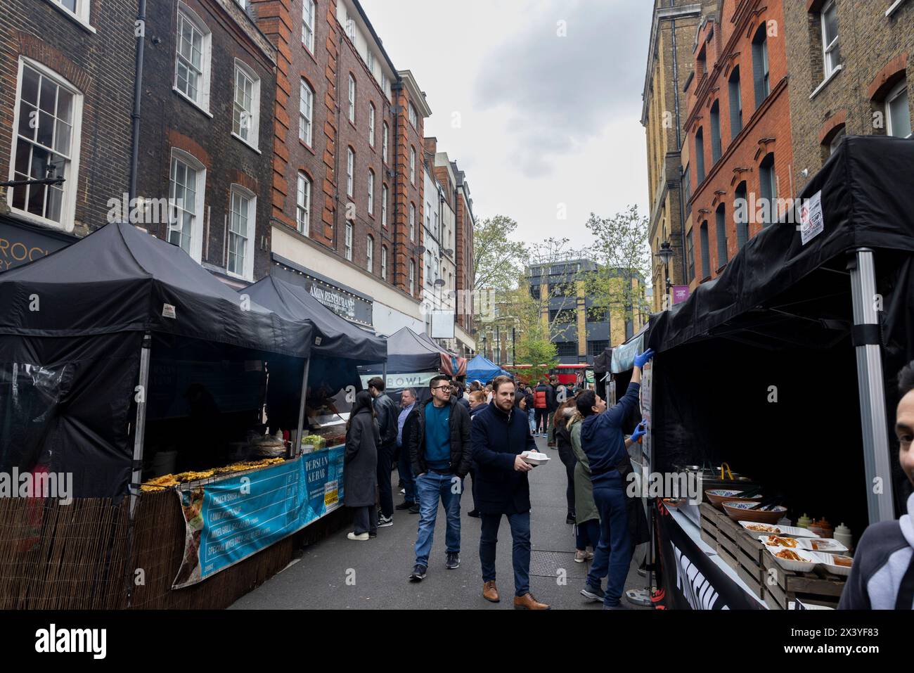 Leather Lane, una strada nel centro di Londra con molte bancarelle che offrono cibo di strada tutti i giorni feriali dalle 10:00 alle 14:00. Pedoni Foto Stock