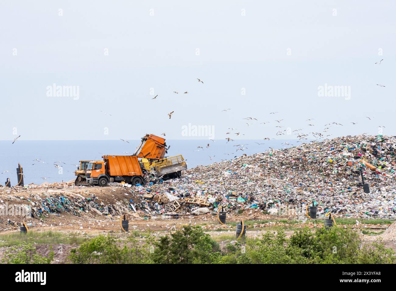 Le macchine stanno lavorando su uno stupido con il mare sullo sfondo Foto Stock