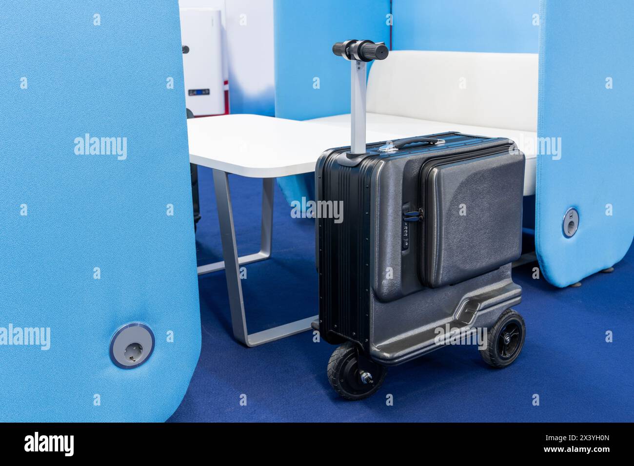 Valigia per scooter elettrico all'aeroporto. Il futuro dei bagagli Foto Stock