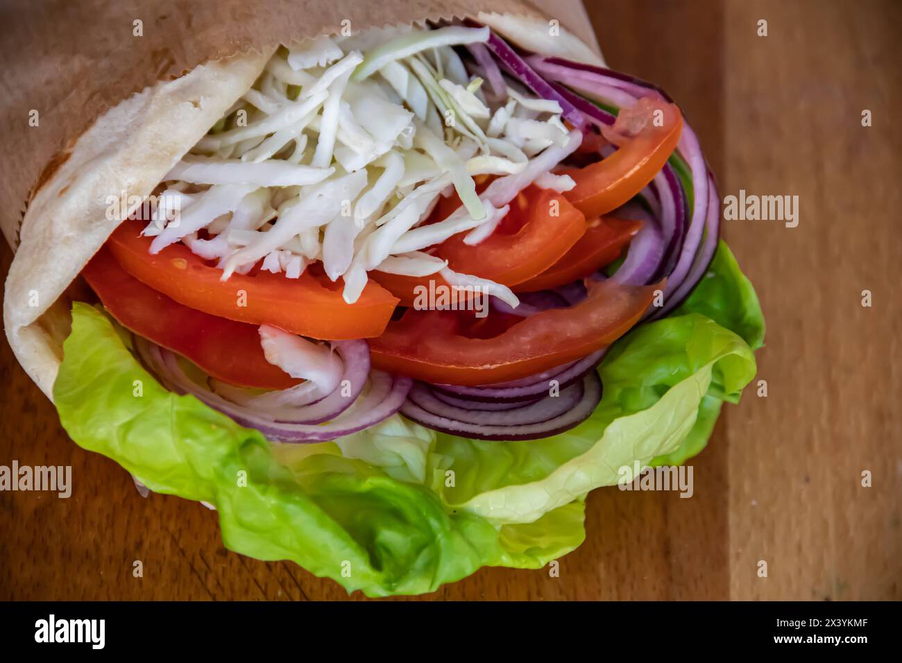 Sandwich vegetariano sano ricco di sapori. insalata verde, pomodori succosi, formaggio bianco e cipolle saporite, il tutto tra le fette di pane fresco Foto Stock