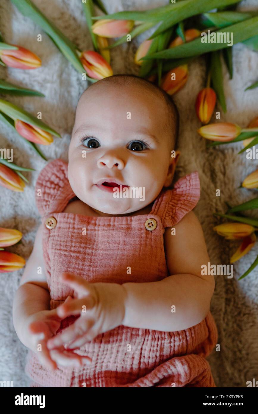 Occhi pieni di meraviglia di una bambina tra i tulipani Foto Stock