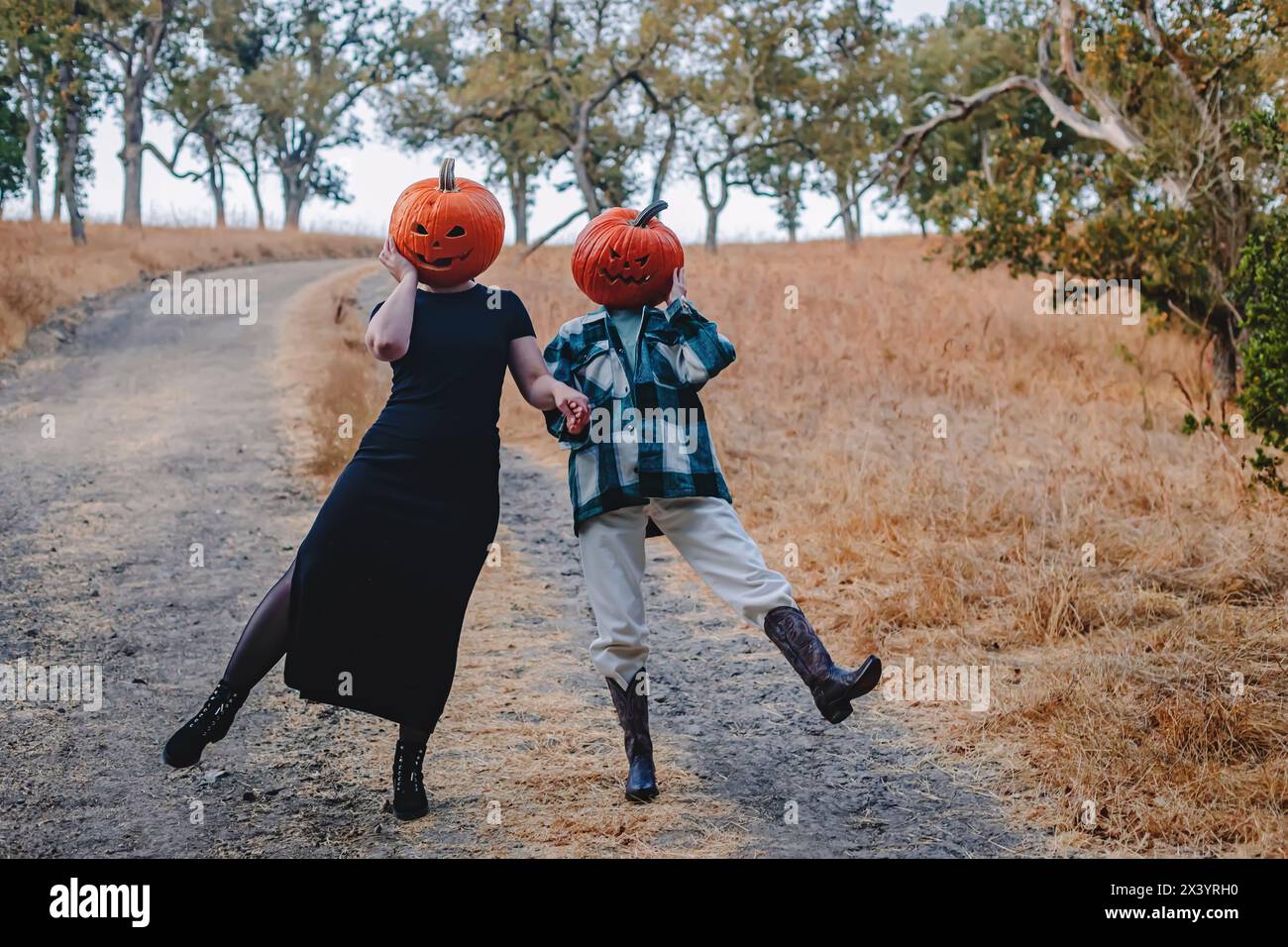 Due amiche che indossano teste di zucca intagliate Foto Stock