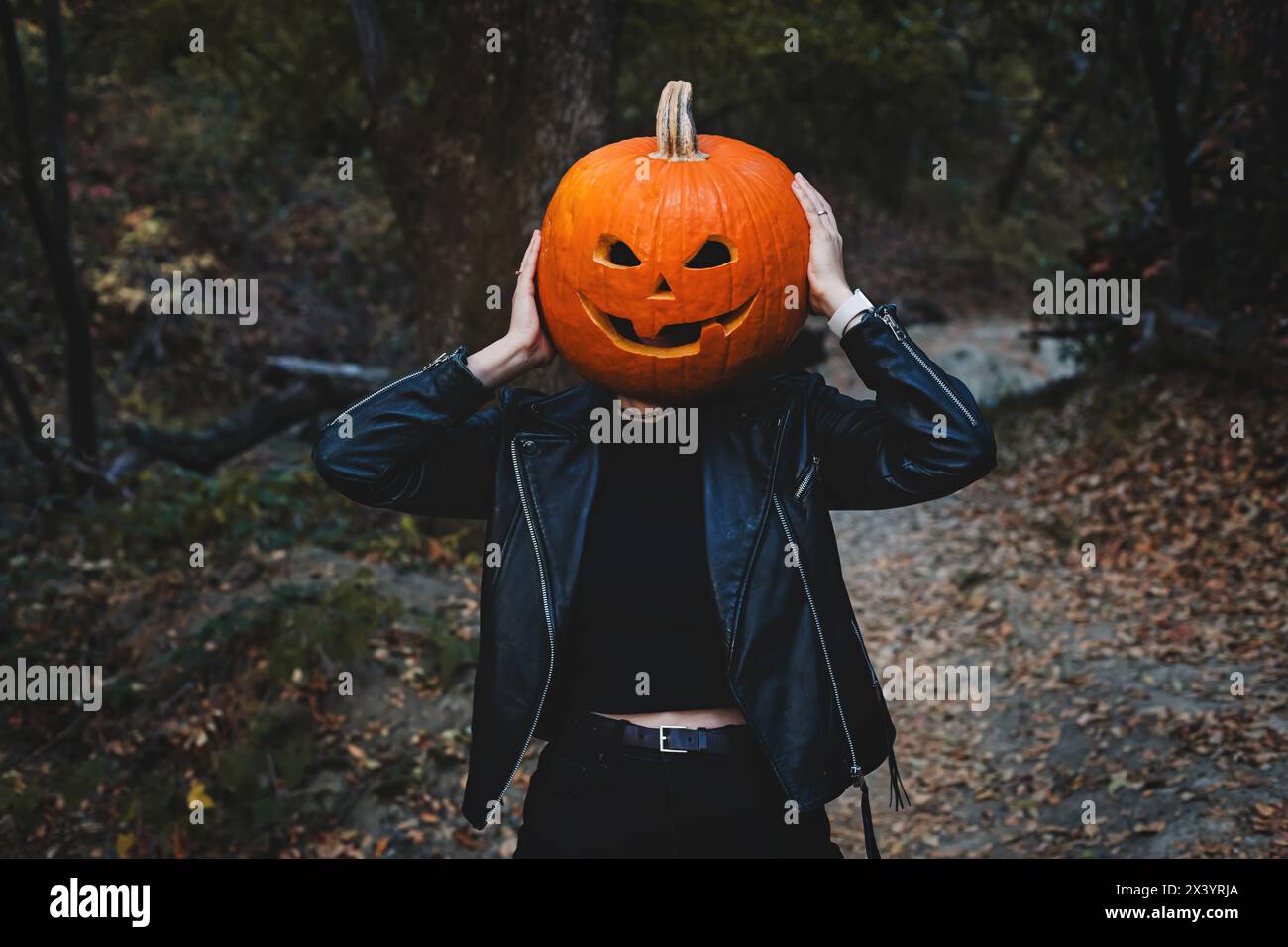 Persona che indossa la testa di zucca scolpita di Halloween con faccia divertente Foto Stock