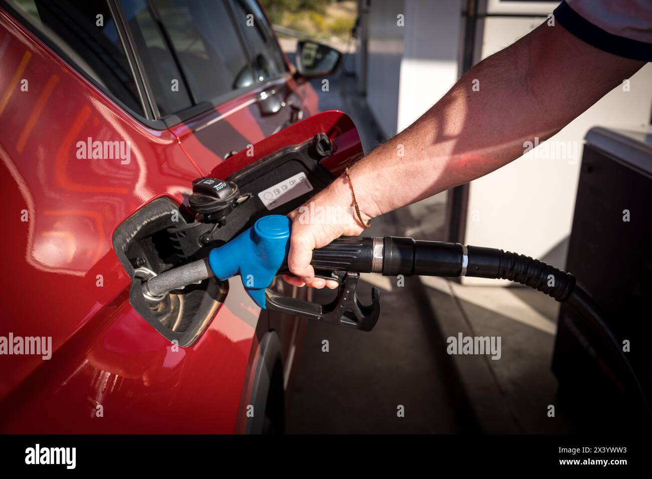 uomo mano il rifornimento di benzina e il riempimento del serbatoio presso la stazione di servizio o la stazione di servizio pompa alla vettura rossa Foto Stock