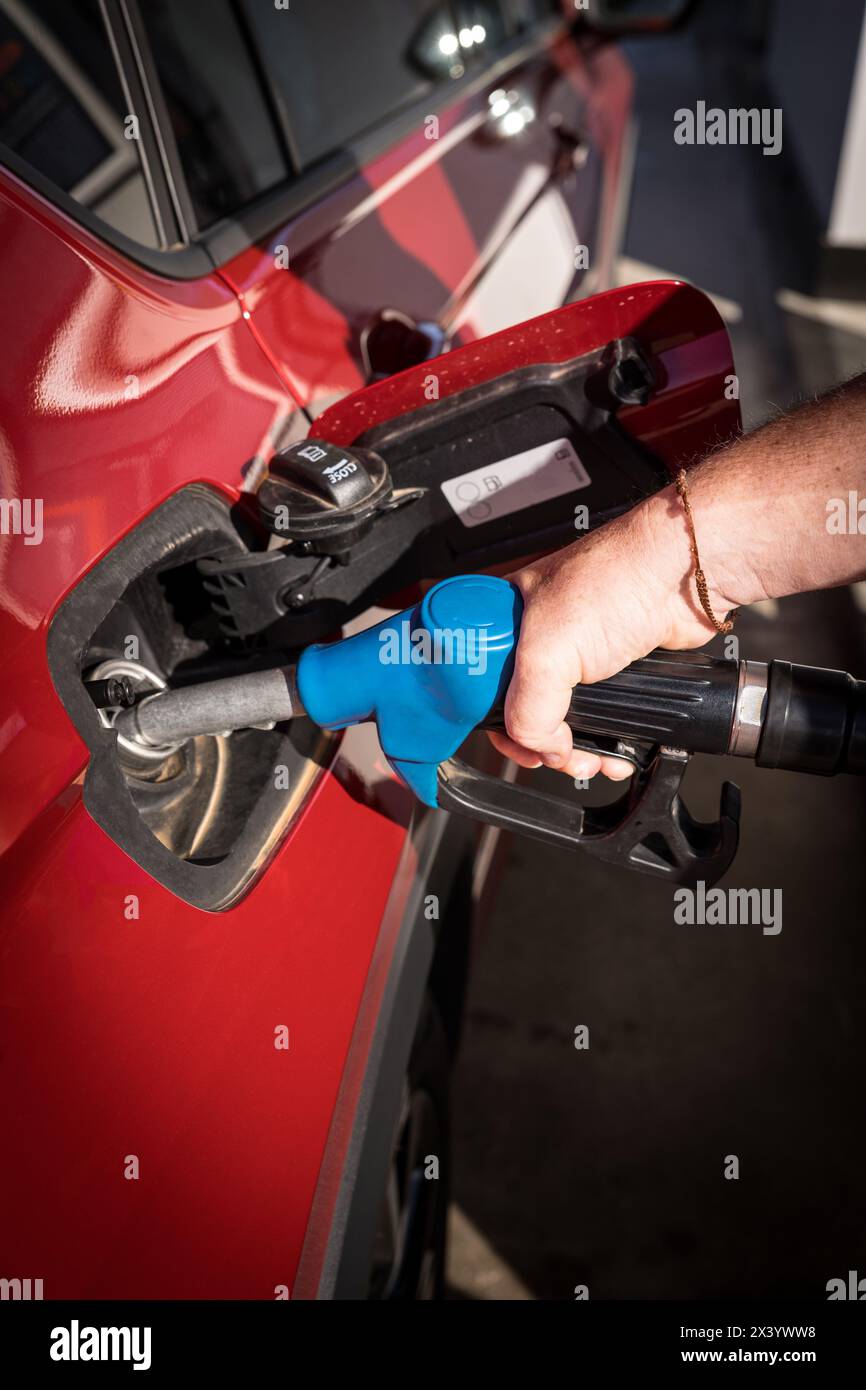 uomo mano il rifornimento di benzina e il riempimento del serbatoio presso la stazione di servizio o la stazione di servizio pompa alla vettura rossa Foto Stock