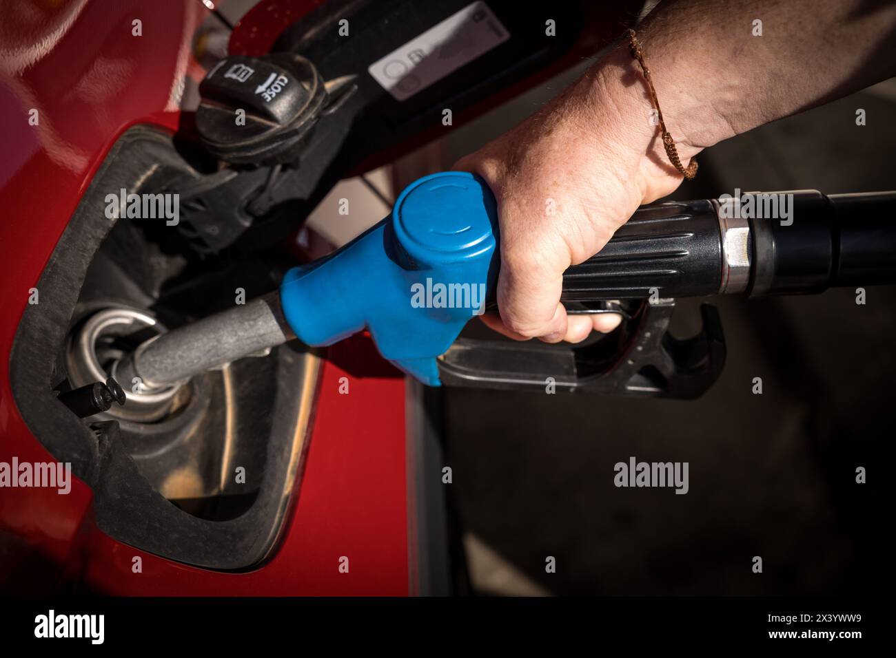 uomo mano il rifornimento di benzina e il riempimento del serbatoio presso la stazione di servizio o la stazione di servizio pompa alla vettura rossa Foto Stock