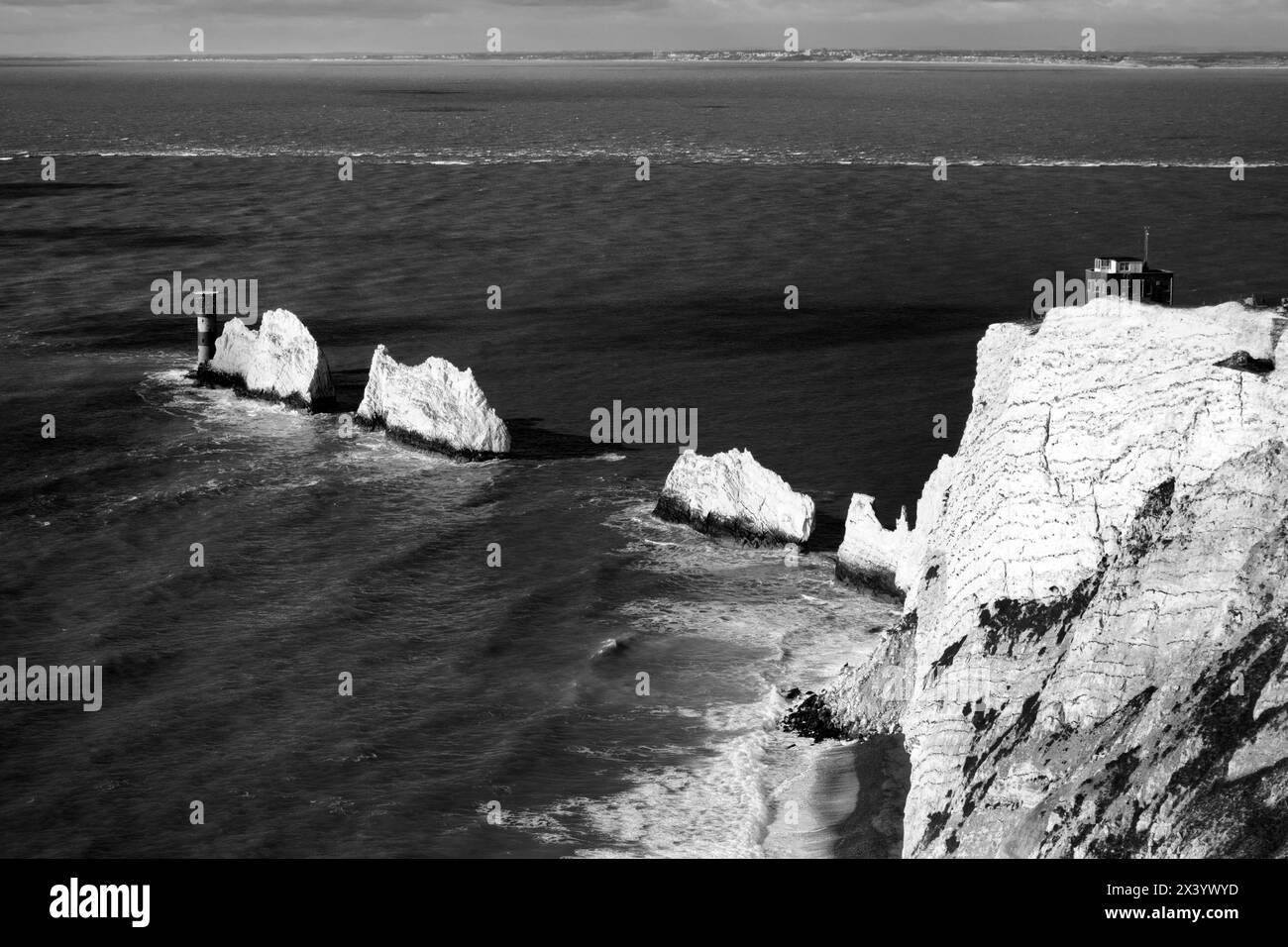 The Needles, una fila di tre pile di gesso al largo della costa occidentale dell'Isola di Wight, che si innalzano a circa 30 m dal mare, con il faro di Needles oltre Foto Stock