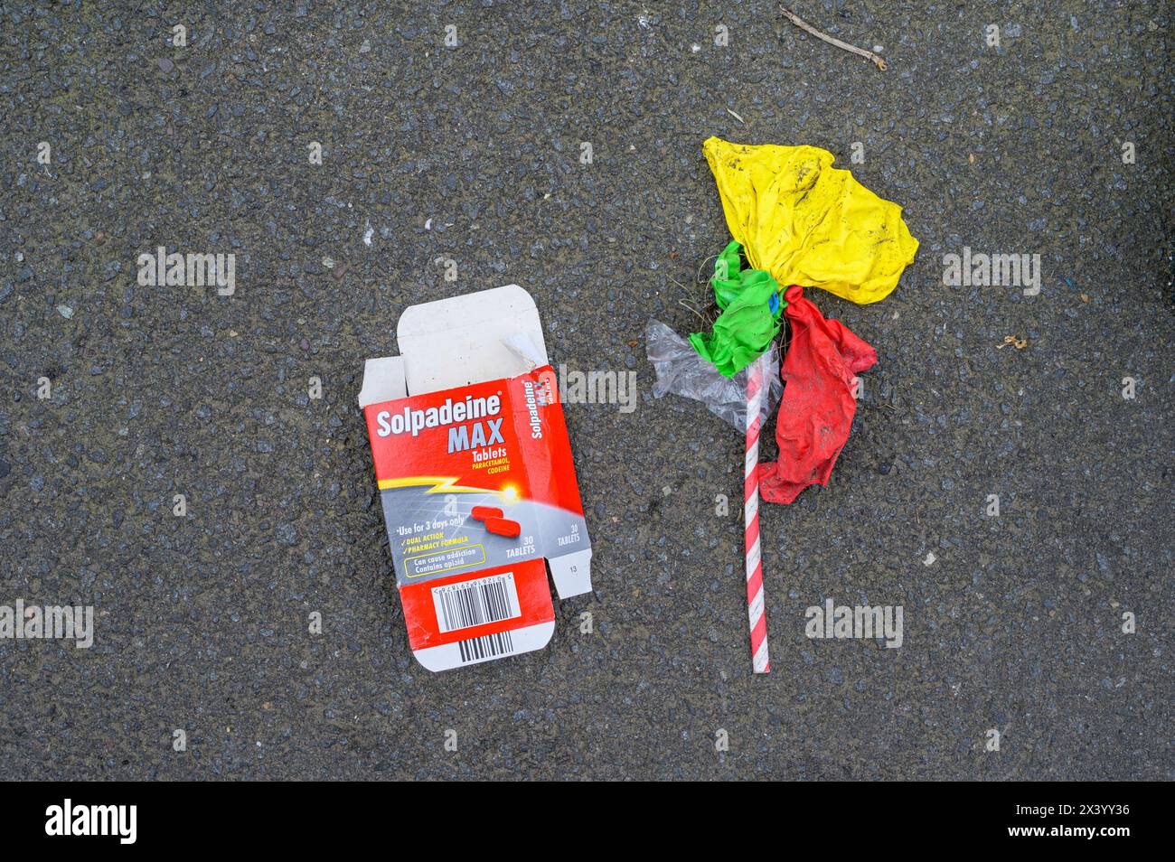 Un pacchetto vuoto di compresse Solpadeine Max steso su un marciapiede accanto a palloncini esplosi Foto Stock