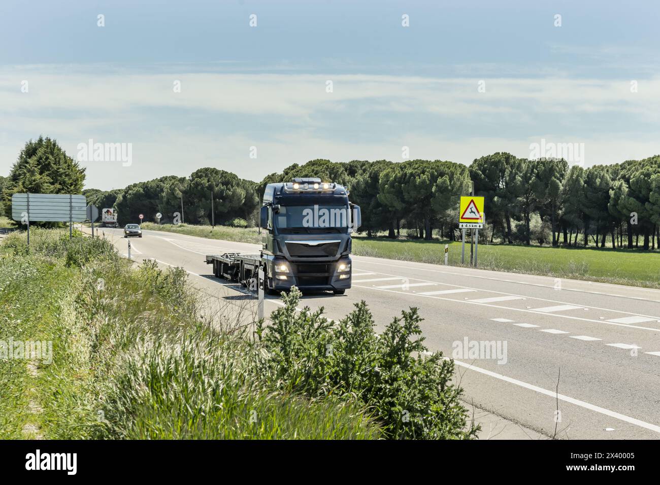 Un trattore motrice che guida con un rimorchio vuoto Foto Stock