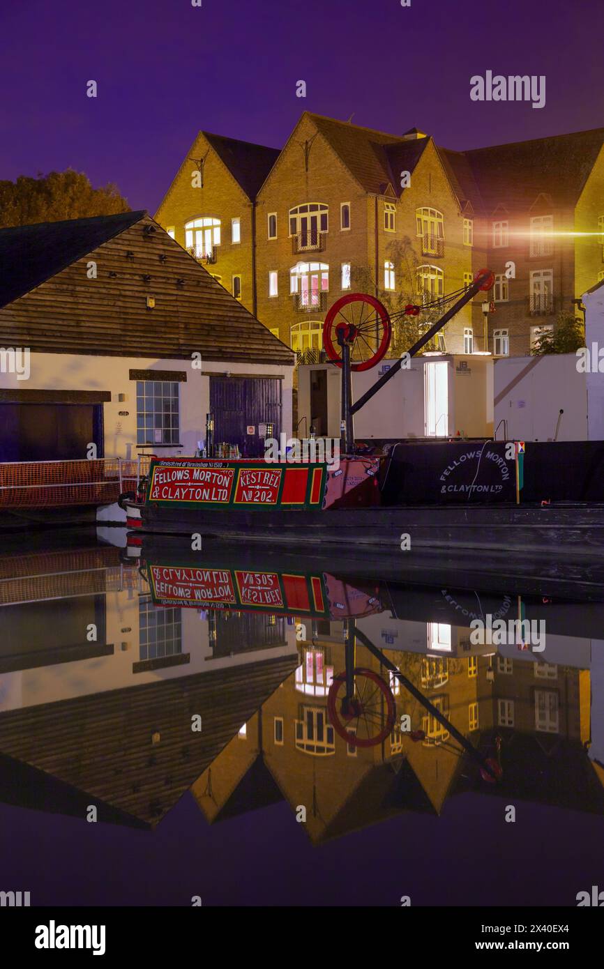 Inghilterra, Northamptonshire, Braunston Marina di notte con case e ingresso al bacino di carenaggio Foto Stock