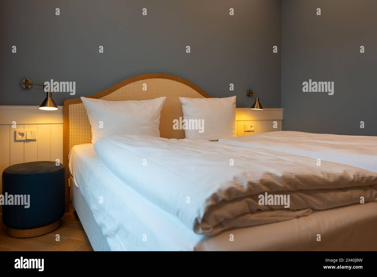 Grandi comodini con letto matrimoniale e lampade nella camera dell'hotel. Arredi per hotel. Foto Stock