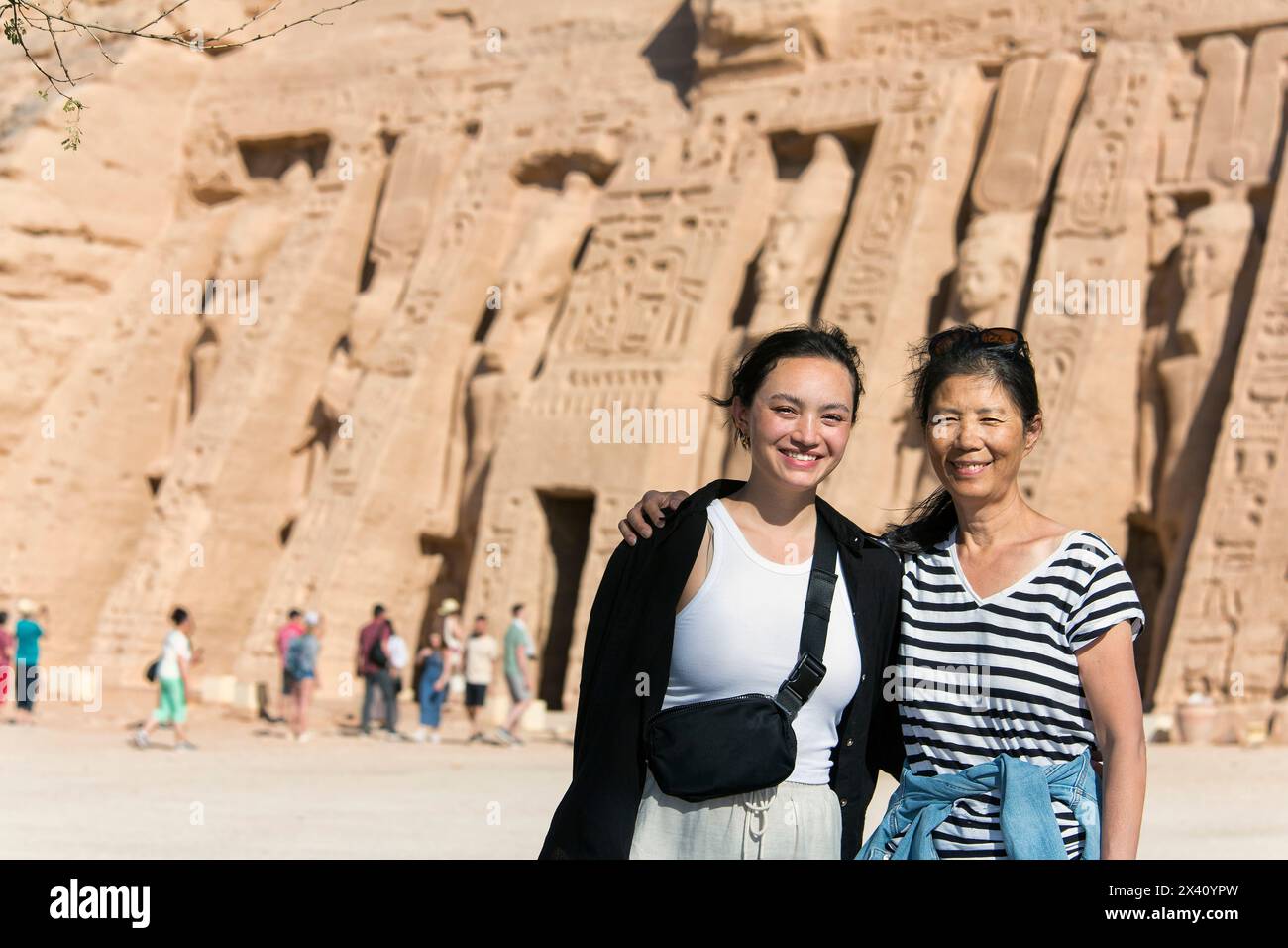 Madre e figlia di turisti in piedi di fronte al Tempio di Hathor ad Abu Simbel; Assuan, Nubia, Egitto Foto Stock