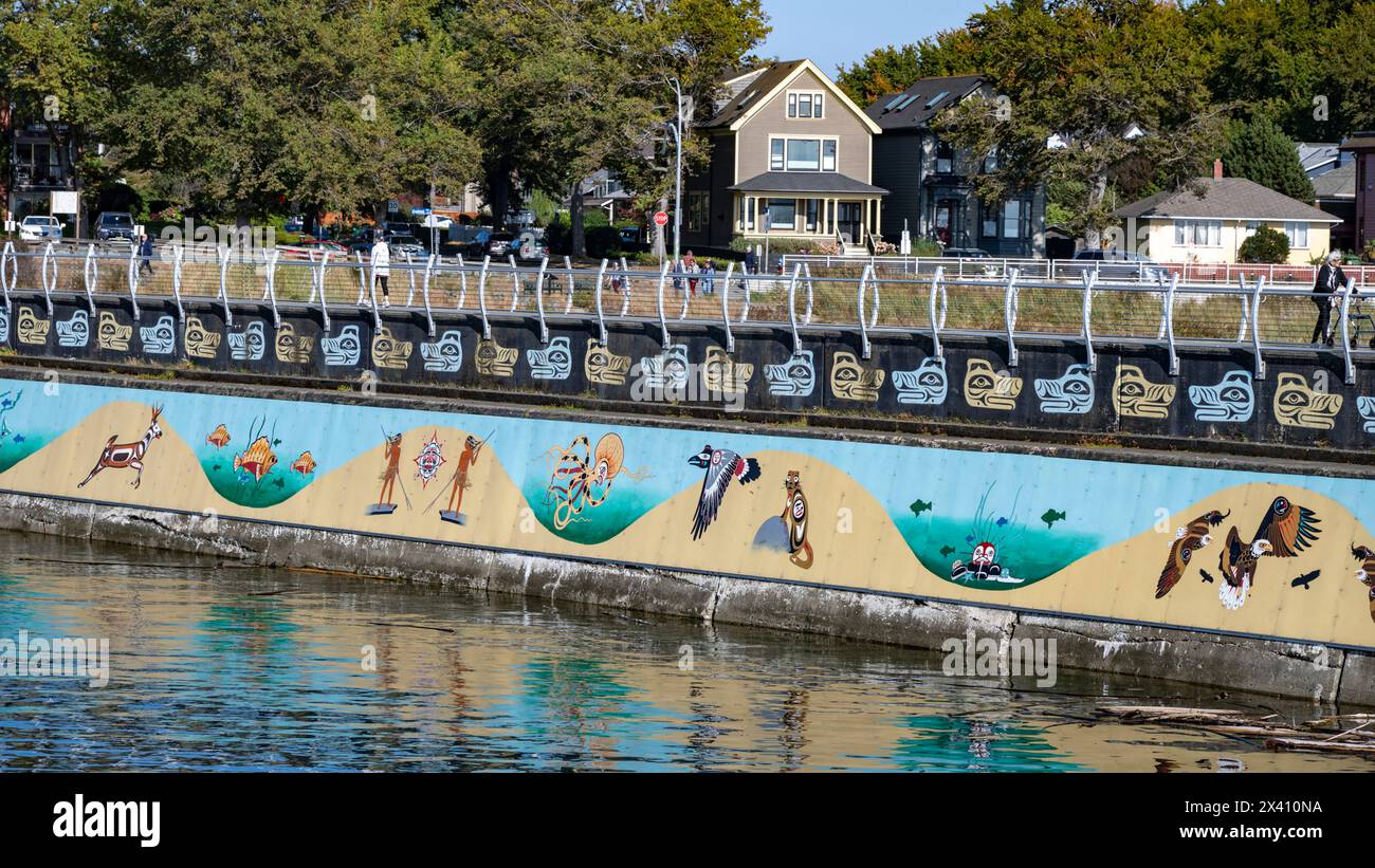 Opere d'arte dipinte a tema indigeno decorano una diga sul lungomare di Ogden Point, una struttura portuale di acque profonde situata nell'angolo sud-occidentale o... Foto Stock