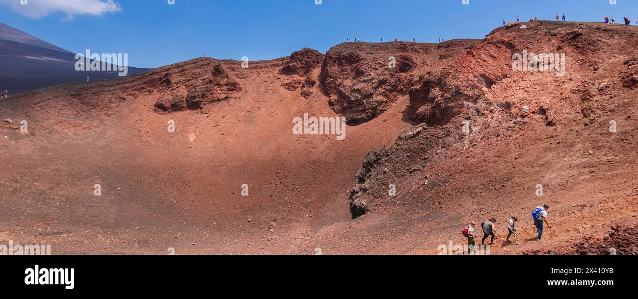 I turisti che scalano l'Etna in una giornata di sole, con i turisti in lontananza sul ridgeline; Catania, Sicilia, Italia Foto Stock