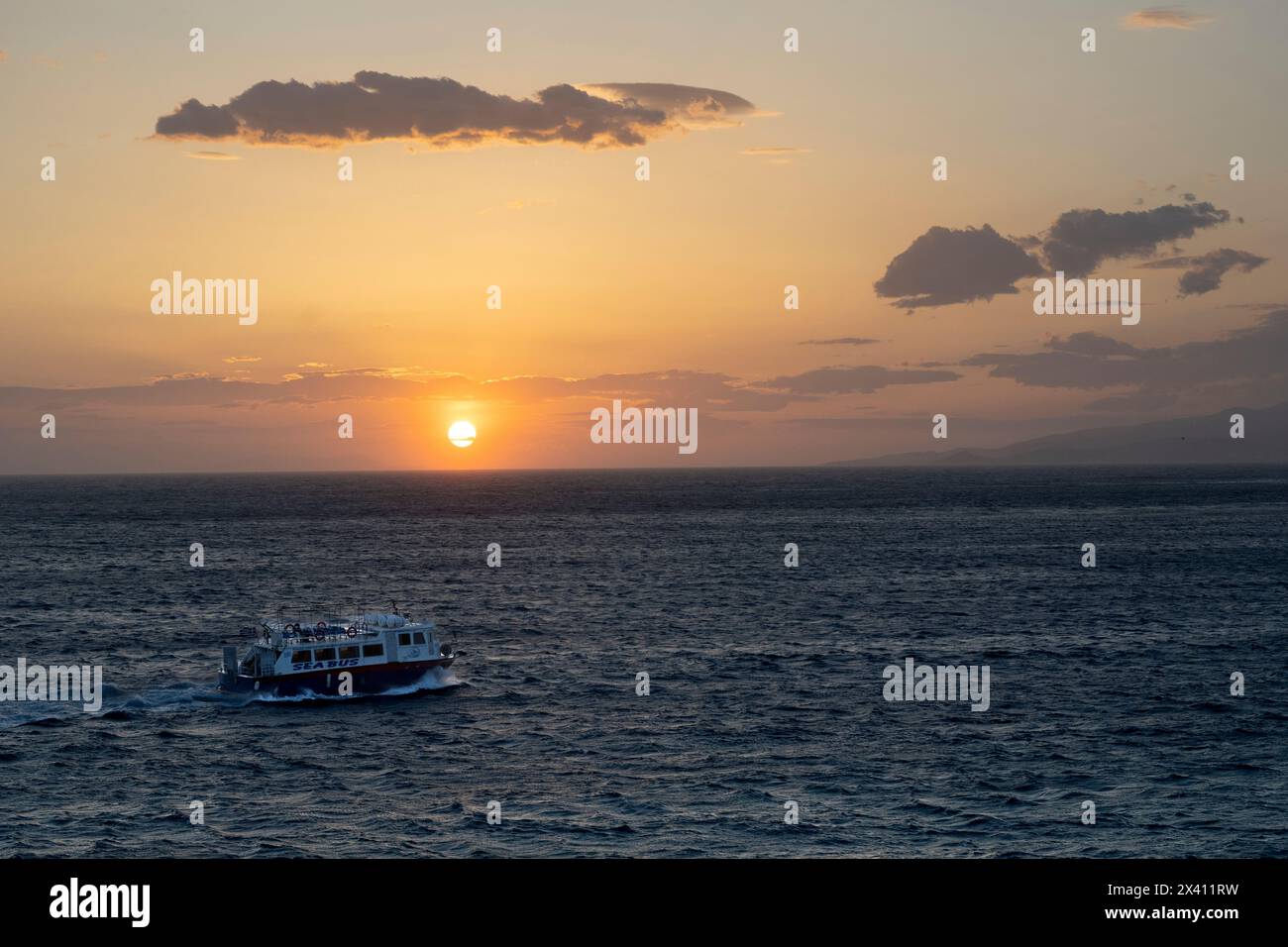 L'autobus marittimo attraversa l'acqua al tramonto nelle isole greche; Mykonos, Egeo meridionale, Grecia Foto Stock